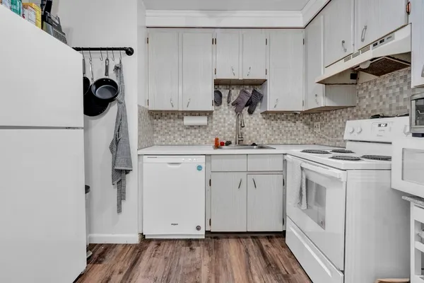 a kitchen with white cabinets and white appliances