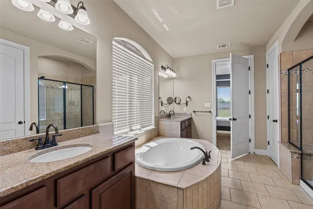 a bathroom with a granite countertop sink a toilet a mirror and shower