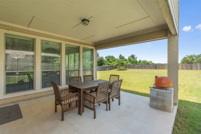 a dining room with furniture and a floor to ceiling window