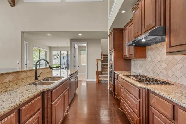 a kitchen with stainless steel appliances granite countertop a sink stove and cabinets