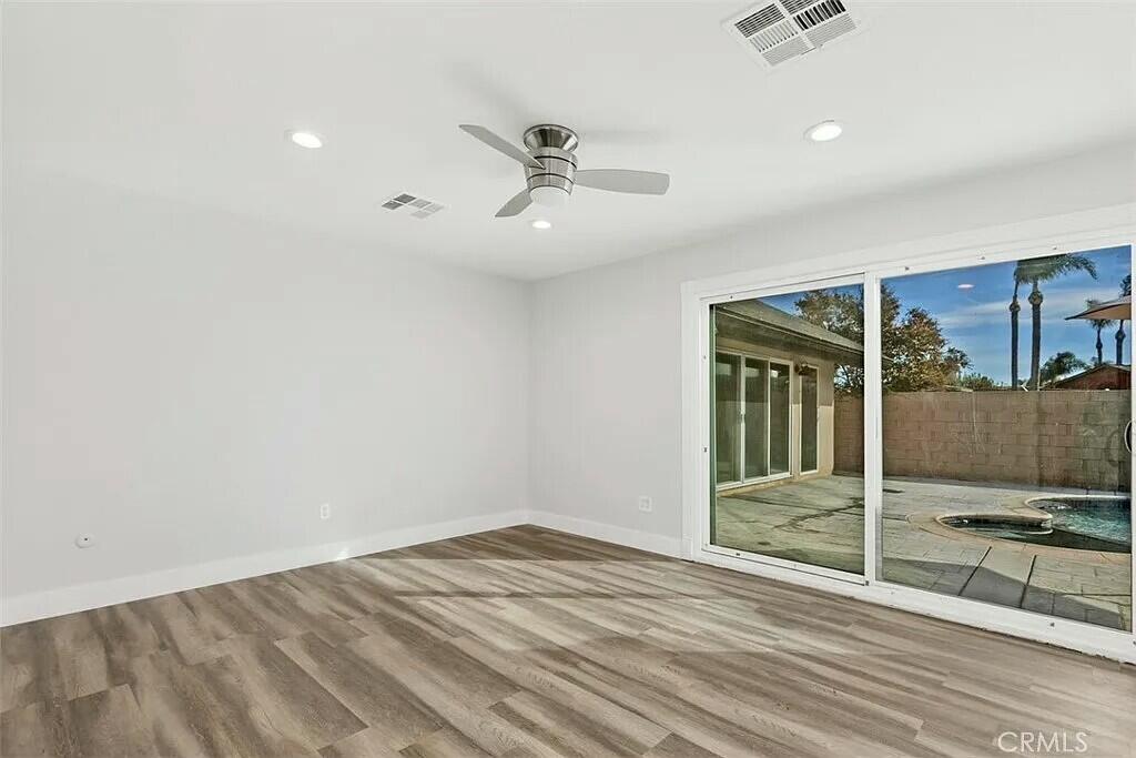 11228 Cameron Drive Riverside, CA 92505 - Photo 18 of 28 an empty room with wooden floor and windows