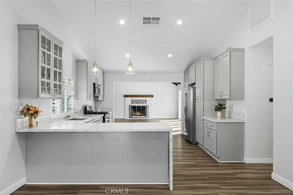 11228 Cameron Drive Riverside, CA 92505 - Photo 5 of 28 a large kitchen with stainless steel appliances a large counter top a stove and a refrigerator