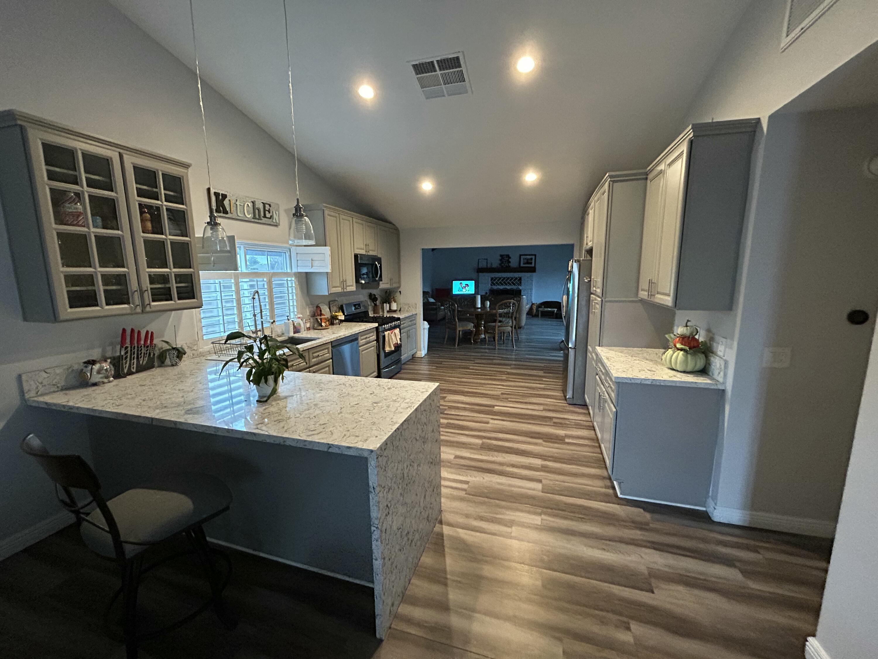 11228 Cameron Drive Riverside, CA 92505 - Photo 7 of 28 a large kitchen with kitchen island a large counter space a sink a window and appliances