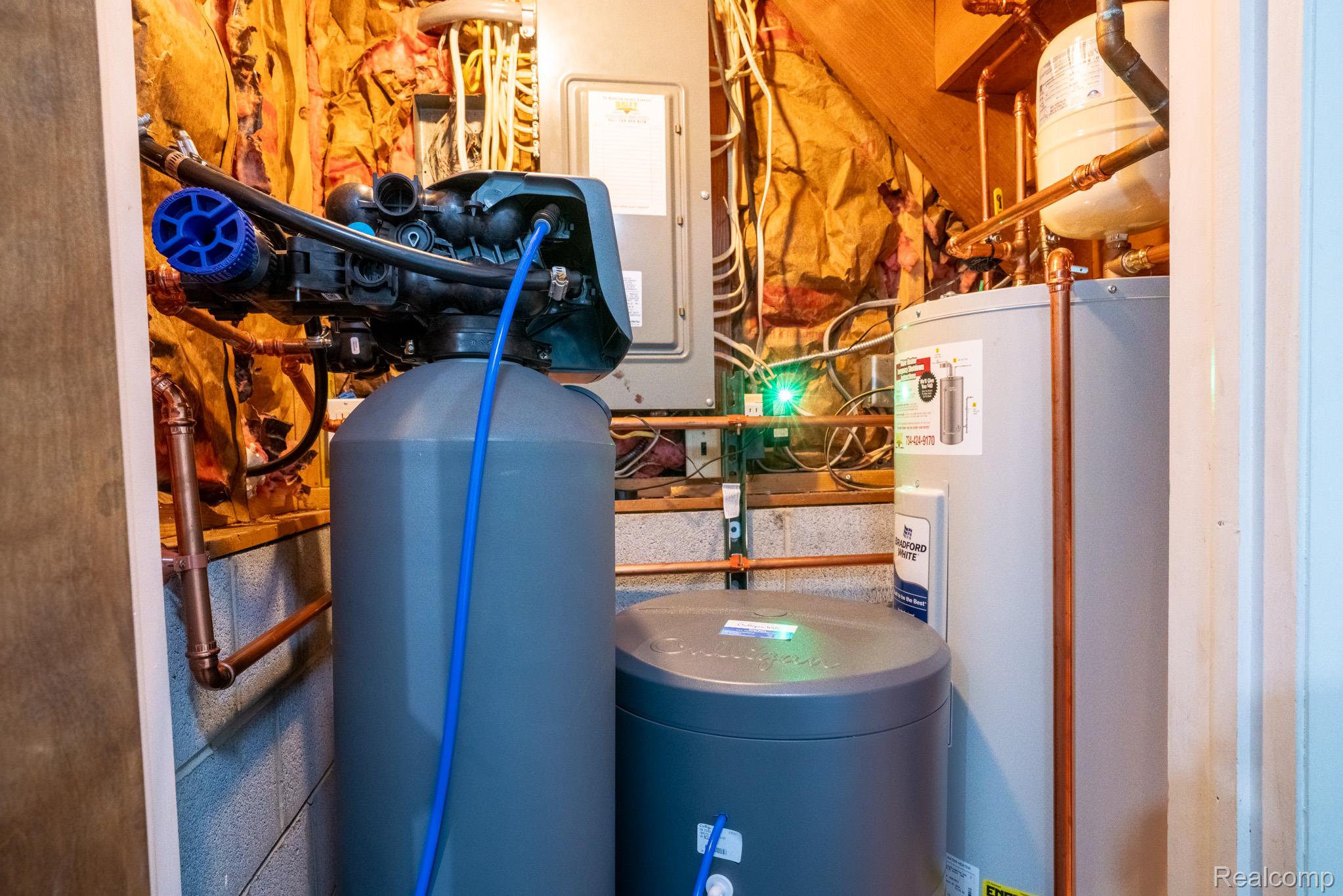 7333 Toma Road Dexter, MI 48130 - Photo 45 of 45 Utility area featuring a water softener system, water heater, copper plumbing, and exposed insulation