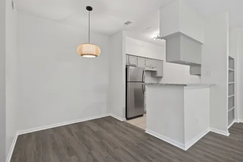 a kitchen with a refrigerator a microwave and wooden floor
