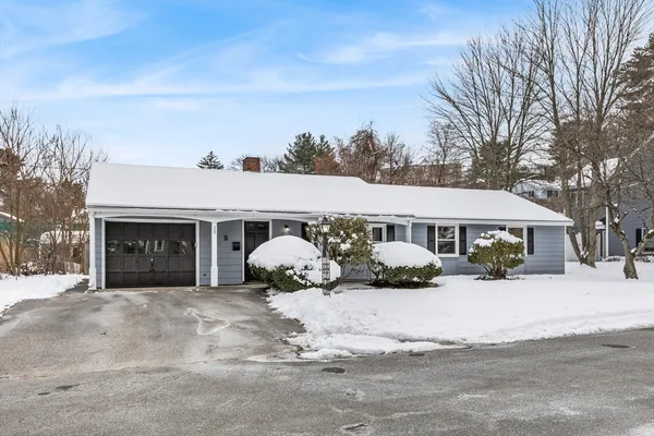 a front view of a house with a yard covered in snow