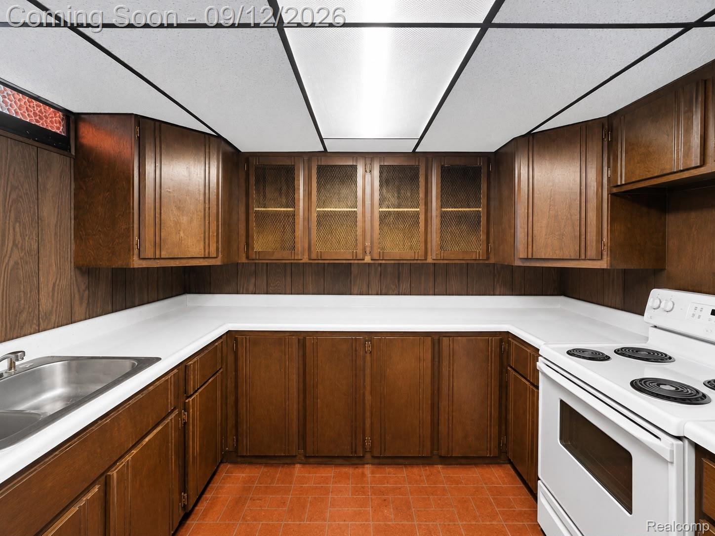 34398 Greentrees Road Sterling Heights, MI 48312 - Photo 26 of 36 U-shaped kitchen layout featuring wood-finish cabinetry, white countertops, and a stainless steel sink