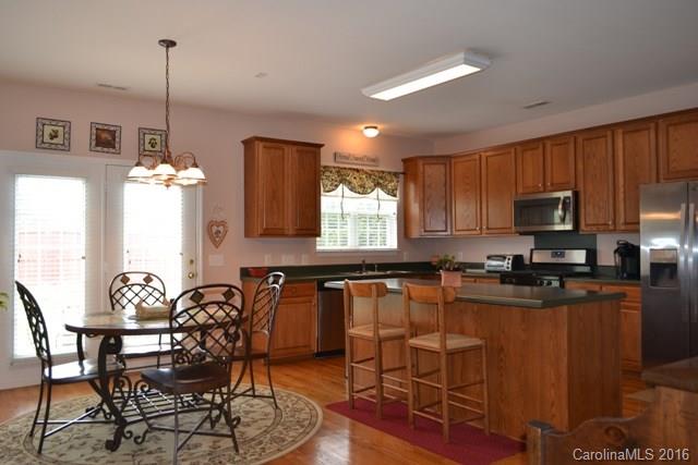 408 Lafinca Court Fort Mill, SC 29708 - Photo 6 of 20 a kitchen with granite countertop a table chairs stove microwave and cabinets