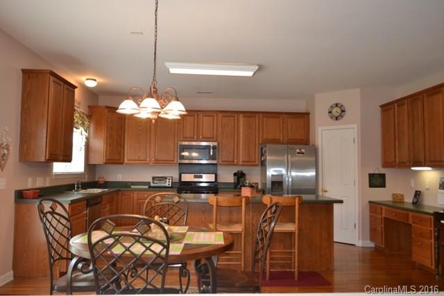 408 Lafinca Court Fort Mill, SC 29708 - Photo 7 of 20 a kitchen with stainless steel appliances kitchen island granite countertop a table chairs and a refrigerator