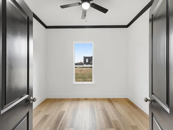 a large white kitchen with wooden floor and a large window