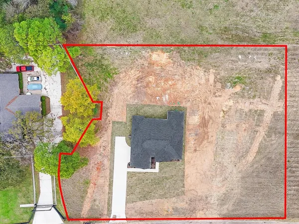 an aerial view of a house with a yard and ocean view