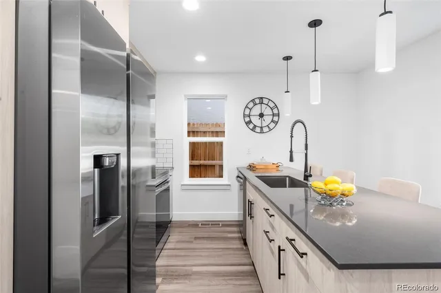 a kitchen with stainless steel appliances granite countertop a sink a stove and refrigerator