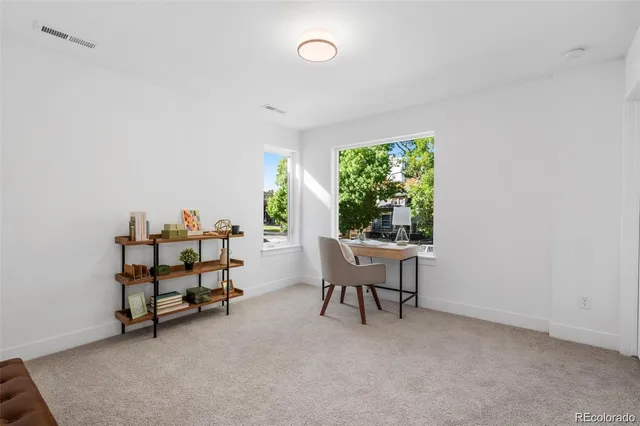 a view of a workspace with furniture and a window