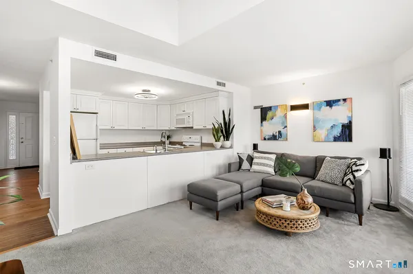 a living room with furniture and a wooden floor