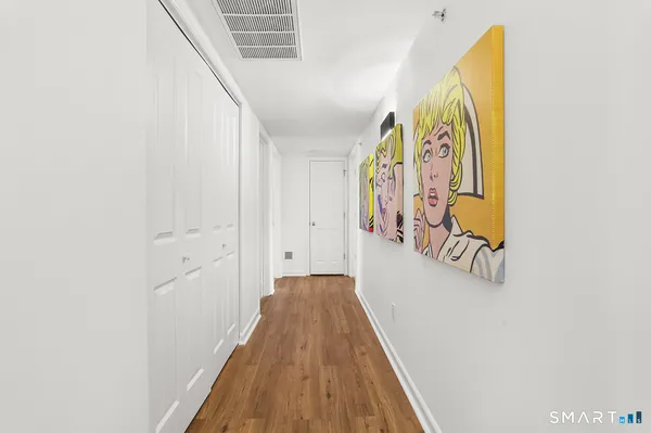 a view of a hallway with wooden floor and stairs