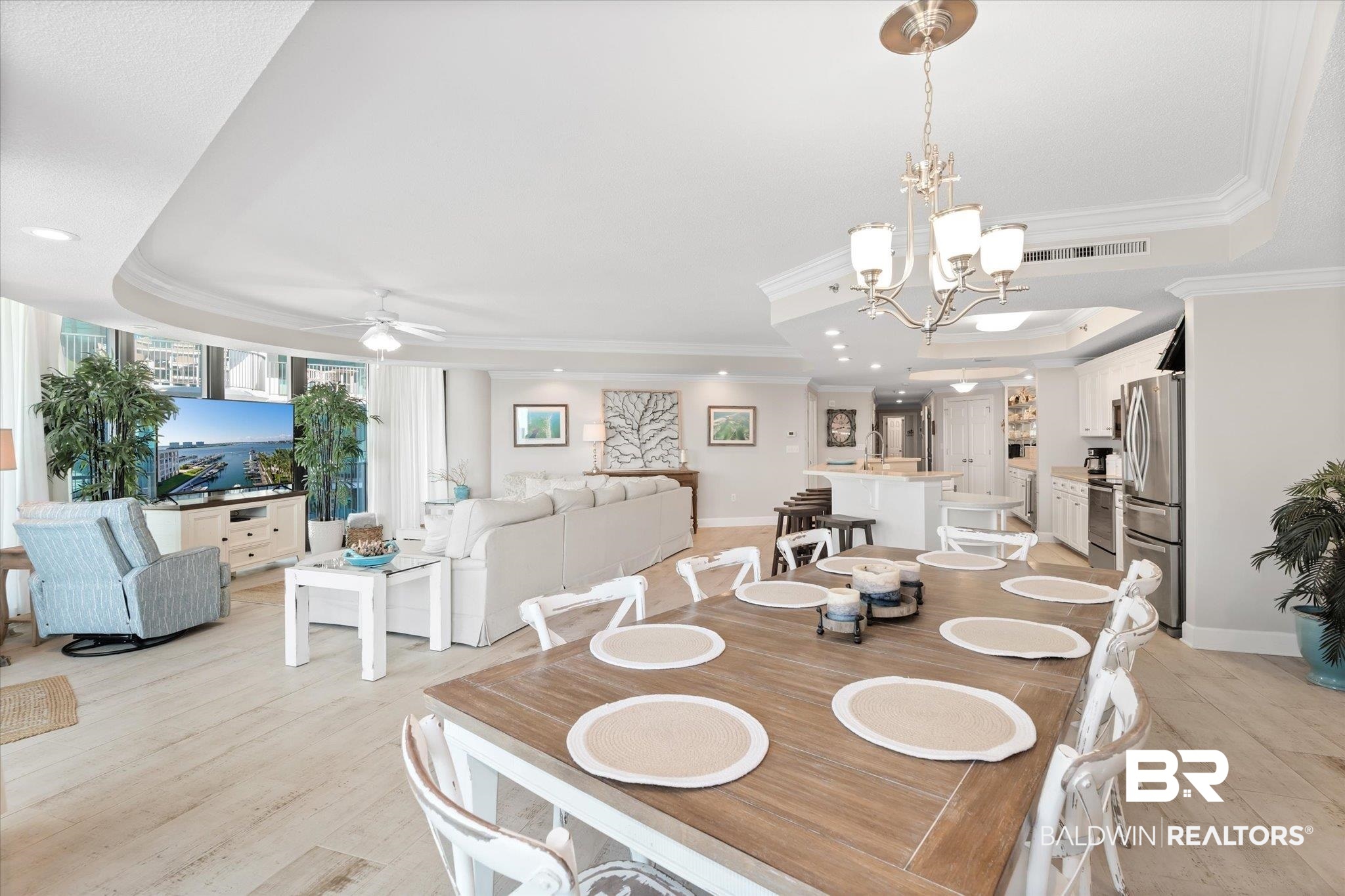 27582 Canal Road, Unit 2611 Orange Beach, AL 36561 - Photo 11 of 37 Dining room featuring ceiling fan with notable chandelier, a tray ceiling, light hardwood / wood-style flooring, and ornamental molding