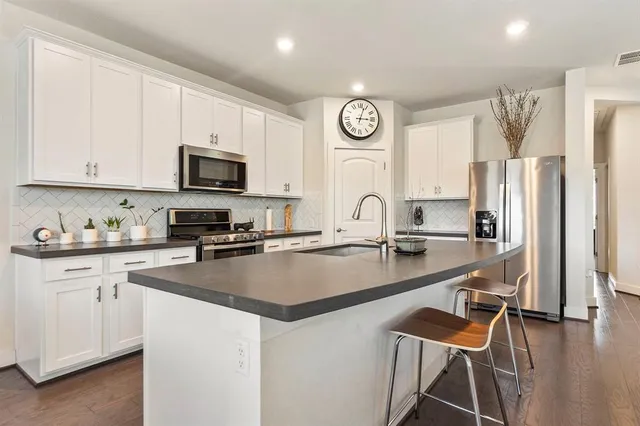 a kitchen with stainless steel appliances granite countertop a stove a sink a refrigerator a microwave and cabinets