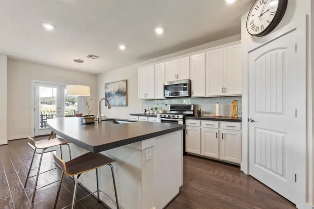 a kitchen with cabinets and chairs