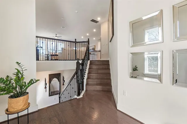a view of a hallway with wooden floor and a potted plant
