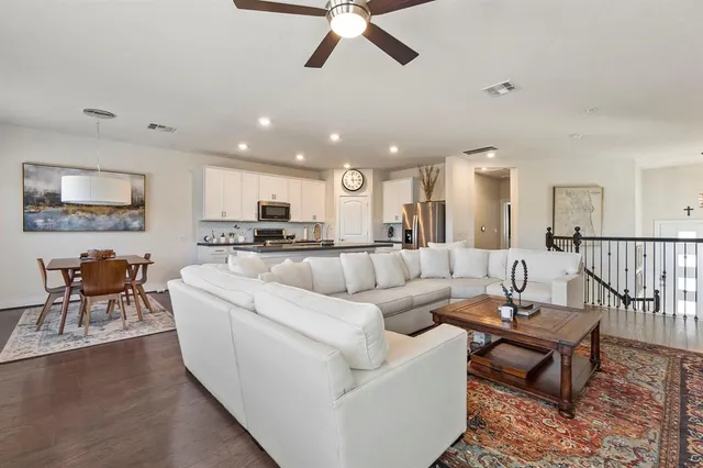 a living room with furniture kitchen view and a chandelier