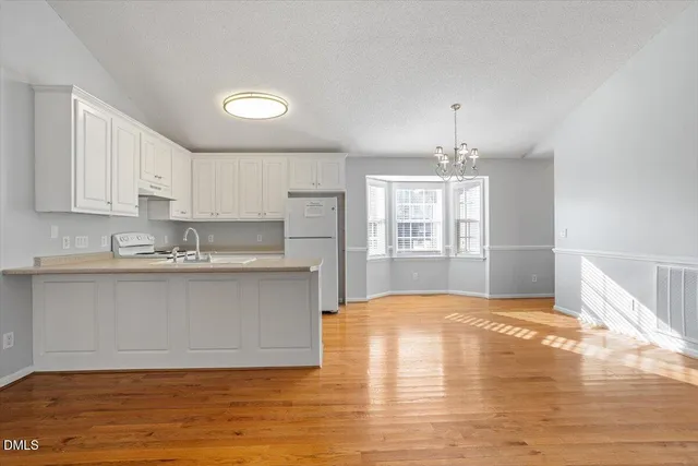 a view of kitchen with granite countertop window and white cabinets