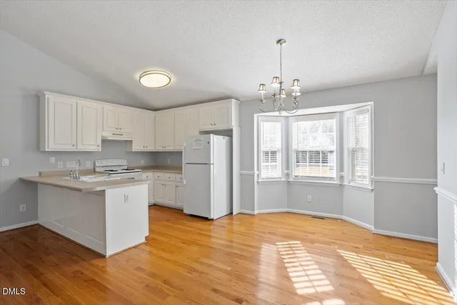 a kitchen with stainless steel appliances granite countertop a stove refrigerator and cabinets