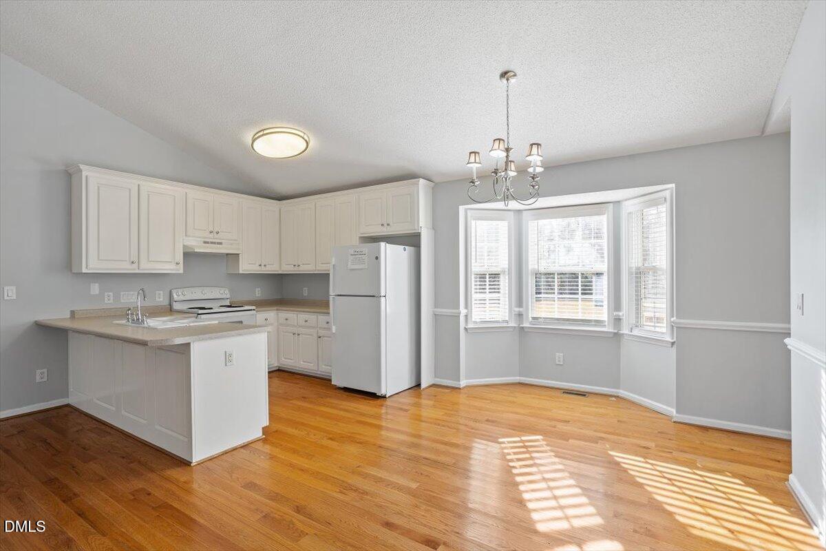 1084 McLemore Road Clayton, NC 27520 - Photo 13 of 34 a kitchen with stainless steel appliances granite countertop a stove refrigerator and cabinets