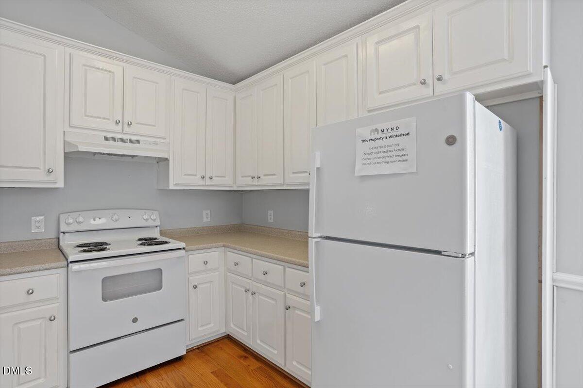 1084 McLemore Road Clayton, NC 27520 - Photo 17 of 34 a kitchen with white cabinets and white appliances