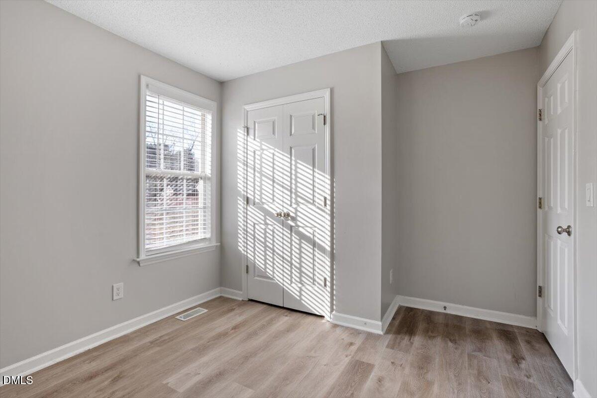 1084 McLemore Road Clayton, NC 27520 - Photo 26 of 34 an empty room with wooden floor and windows