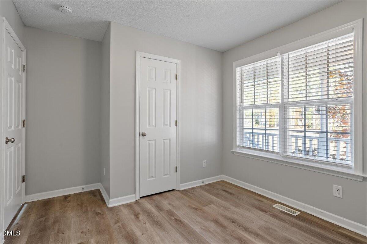 1084 McLemore Road Clayton, NC 27520 - Photo 27 of 34 a view of an empty room with wooden floor and a window