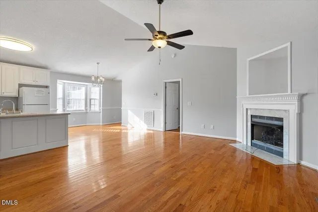 a view of empty room with wooden floor and fireplace