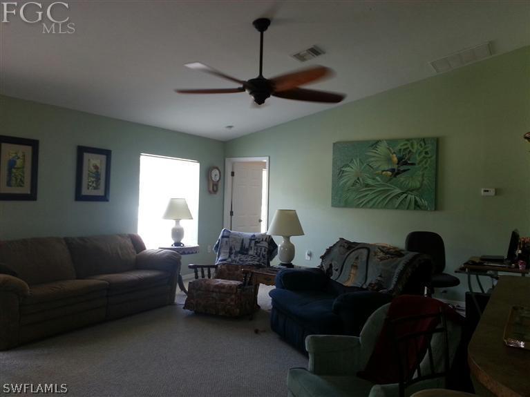 1569 Meadow Road Lehigh Acres, FL 33976 - Photo 9 of 19 a living room with furniture a ceiling fan and a window