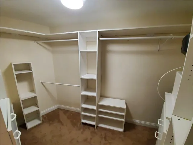 a view of walk in closet with empty racks