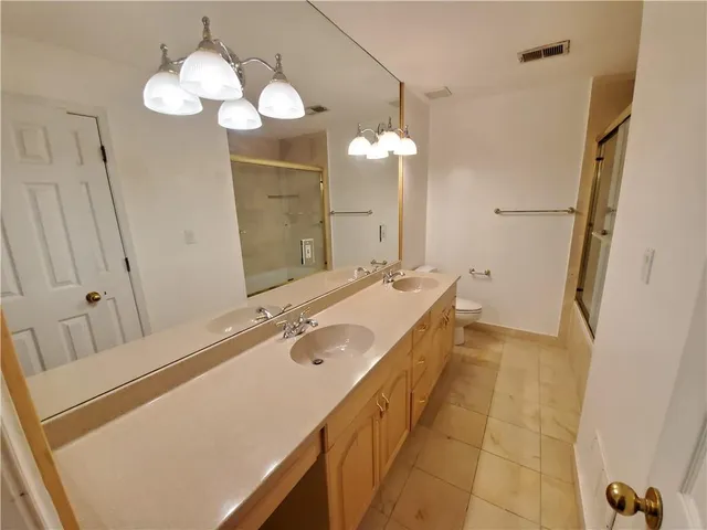 a bathroom with a granite countertop sink a large mirror and a shower