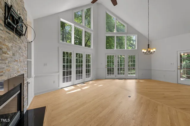 a view of an empty room with a fireplace and windows