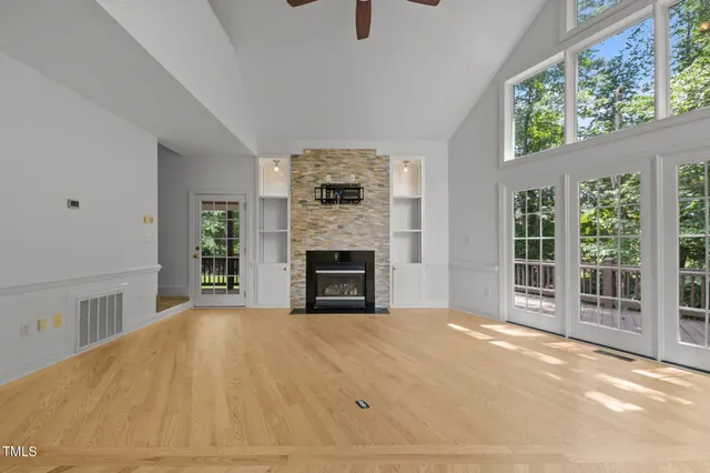 a view of an empty room with a window and a kitchen