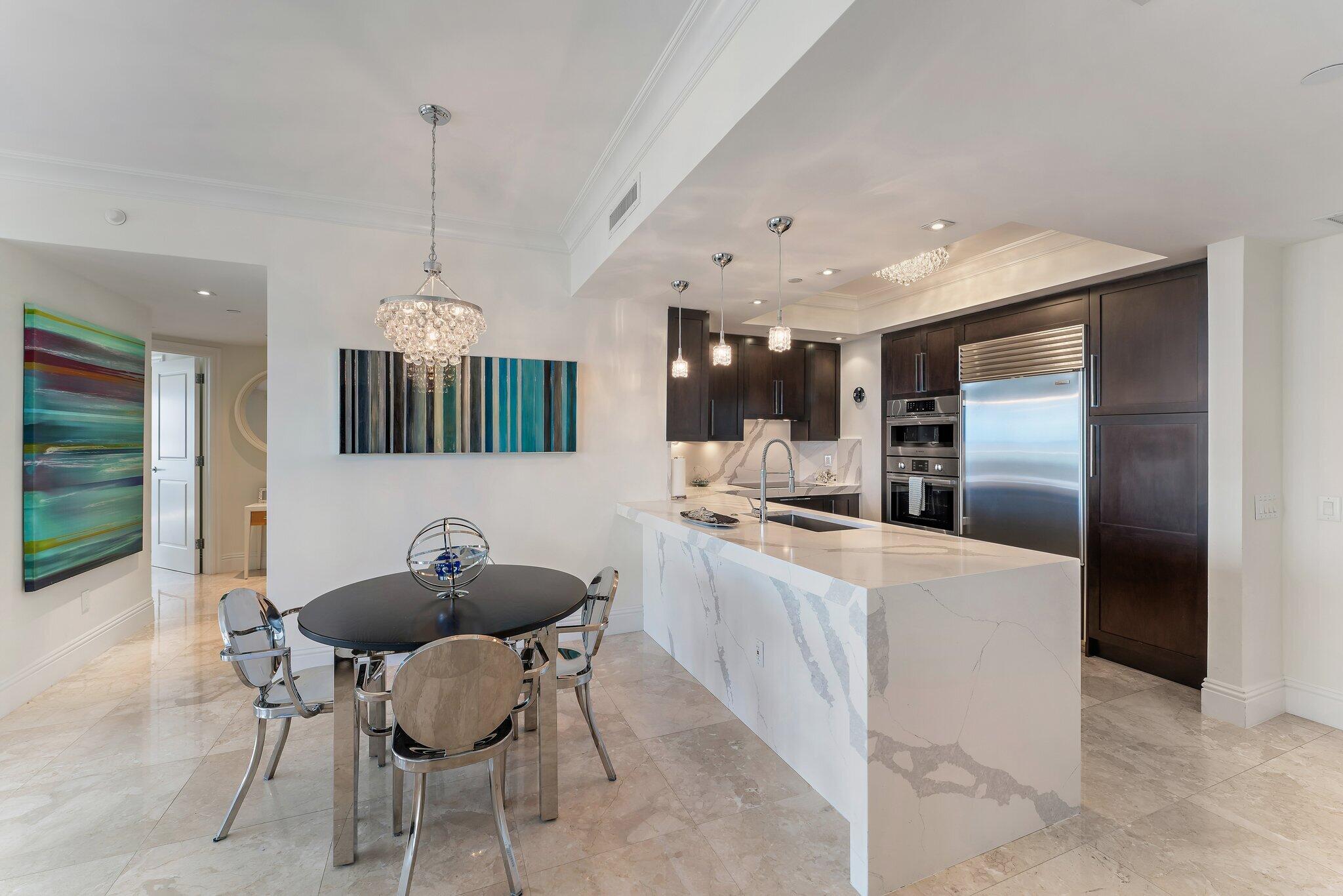 2700 North Ocean Drive, Unit 304B Singer Island, FL 33404 - Photo 50 of 91 a kitchen with stainless steel appliances kitchen island granite countertop a sink a stove and a refrigerator