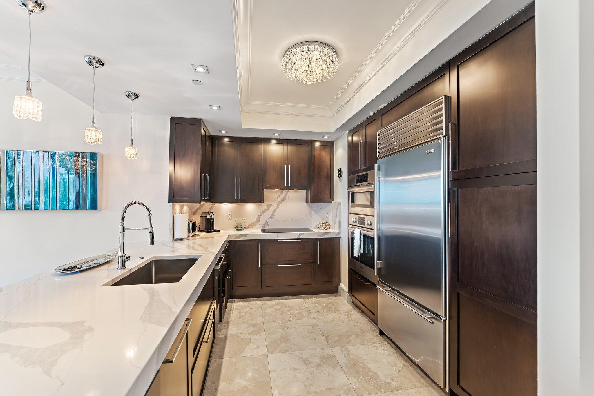 2700 North Ocean Drive, Unit 304B Singer Island, FL 33404 - Photo 54 of 91 a kitchen with kitchen island a counter top space a sink stainless steel appliances and cabinets