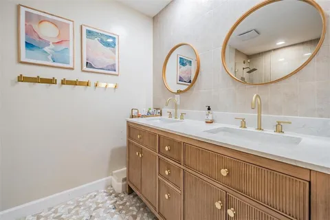 a bathroom with a double vanity sink and a mirror