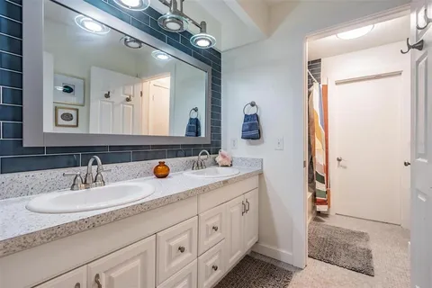 a bathroom with a double vanity sink and a mirror