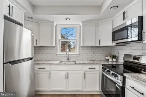 a kitchen with stainless steel appliances granite countertop a refrigerator sink and microwave