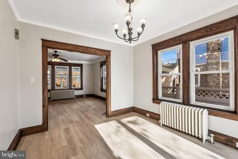 a view of a big room with wooden floor and windows