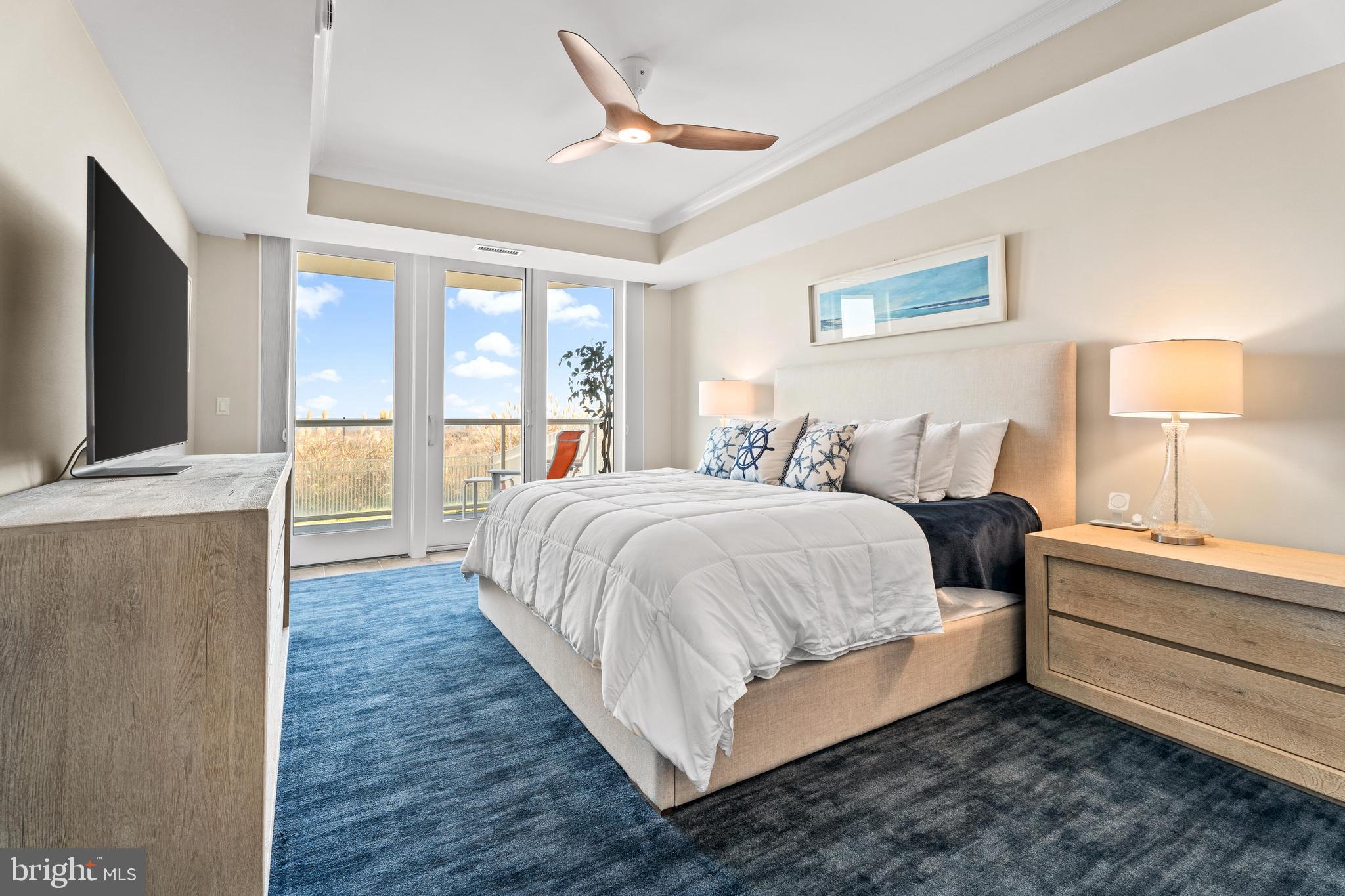 6 60th Street, Unit 102 Ocean City, MD 21842 - Photo 19 of 58 a spacious bedroom with a bed and a flat tv screen on dresser
