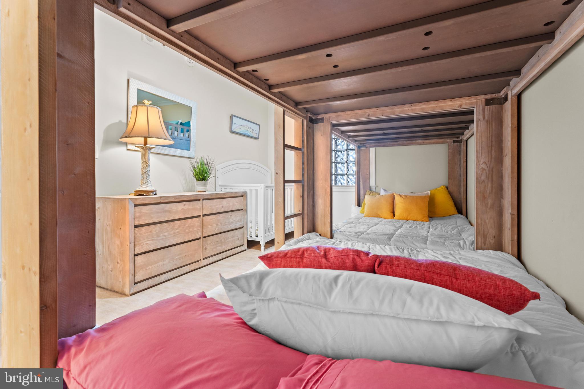 6 60th Street, Unit 102 Ocean City, MD 21842 - Photo 32 of 58 a bedroom with a large bed and a potted plant