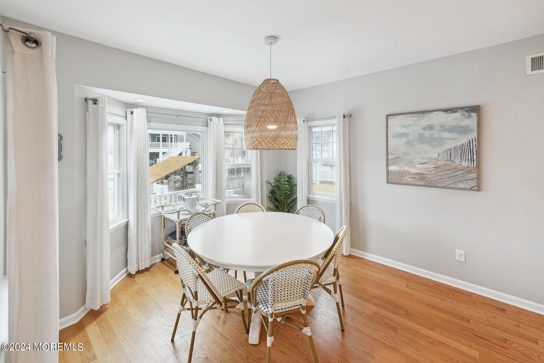 472 Brielle Road Manasquan, NJ 08736 - Photo 16 of 52 a dining room with wooden floor a chandelier a wooden table and chairs