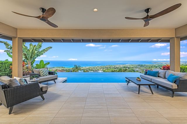a view of swimming pool with seating space and mountain view in the back