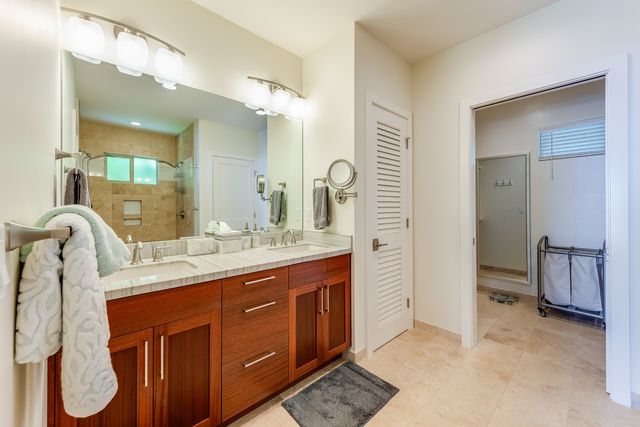 a bathroom with a double vanity sink a mirror and a shower