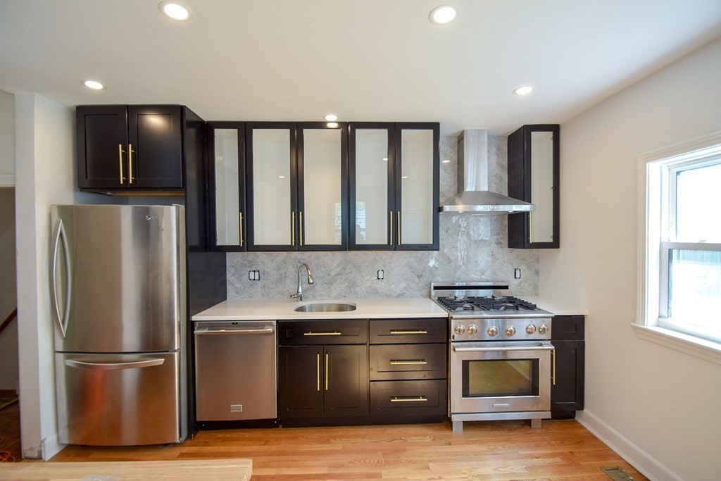 32 Cedar Street, Unit RIGHT Boston, MA 02126 - Photo 2 of 11 a kitchen with stainless steel appliances granite countertop a refrigerator a sink and a stove