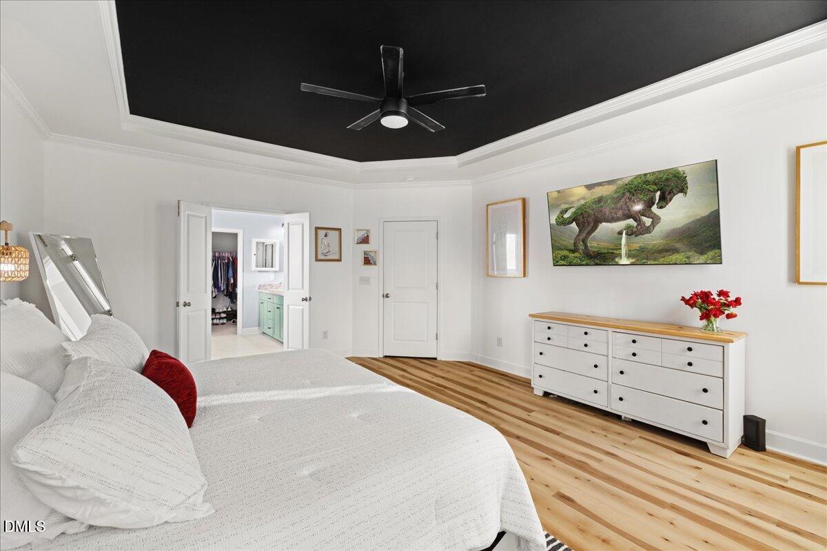 7804 Charters End Street Willow Spring, NC 27592 - Photo 19 of 43 a bedroom with a large bed and a chandelier