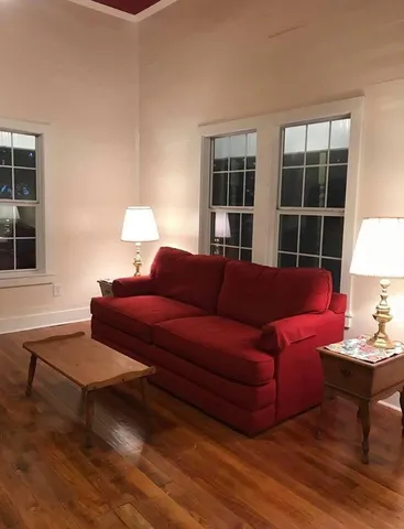 a living room with furniture a lamp and a window